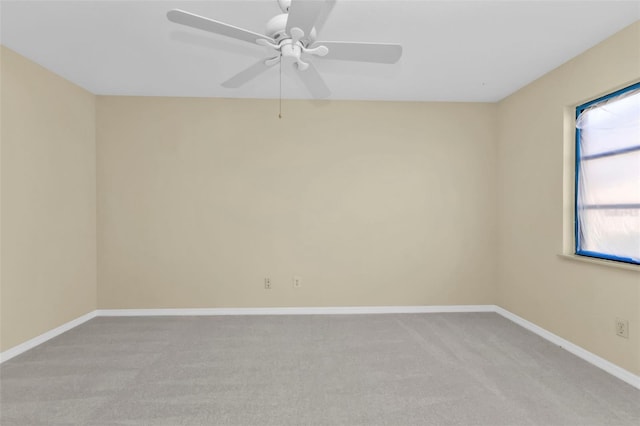 spare room featuring light carpet and ceiling fan