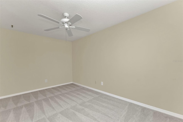 carpeted empty room with ceiling fan and a textured ceiling