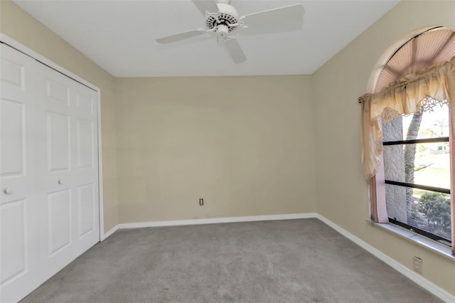 unfurnished bedroom featuring ceiling fan, multiple windows, and a closet