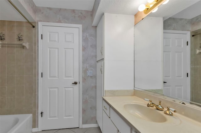 bathroom with a textured ceiling, vanity, tile patterned floors, and tiled shower / bath combo