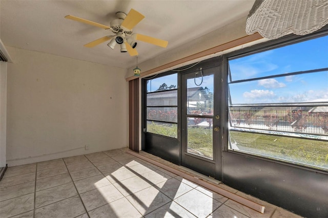 unfurnished sunroom featuring ceiling fan