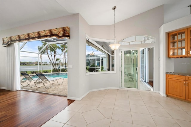 entryway with light tile patterned floors and lofted ceiling