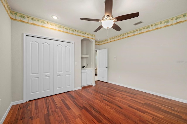 unfurnished bedroom with ceiling fan, dark hardwood / wood-style floors, and a closet