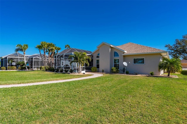 rear view of house featuring a lanai and a lawn