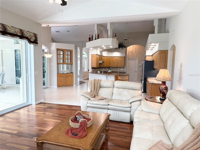 13028 SW Kingsway Cir, Lake Suzy, FL 34269 - living area featuring a ceiling fan, high vaulted ceiling, arched walkways, and light wood-style floors