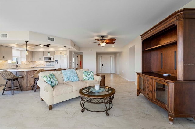 living room with ceiling fan and sink