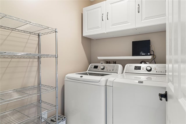 clothes washing area featuring cabinets and washer and dryer