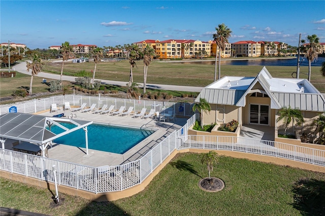 view of swimming pool with a water view, a lawn, a patio, and glass enclosure