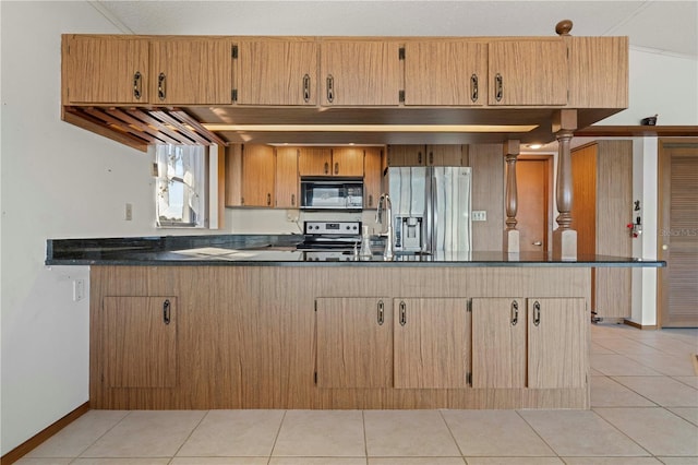 kitchen featuring kitchen peninsula, stainless steel fridge, stove, sink, and light tile patterned floors