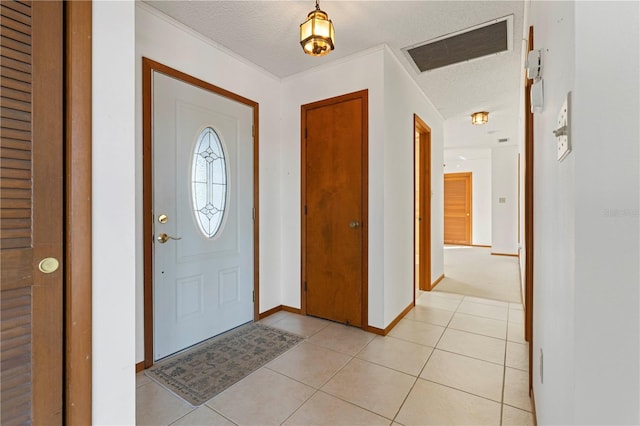 tiled foyer with crown molding and a textured ceiling