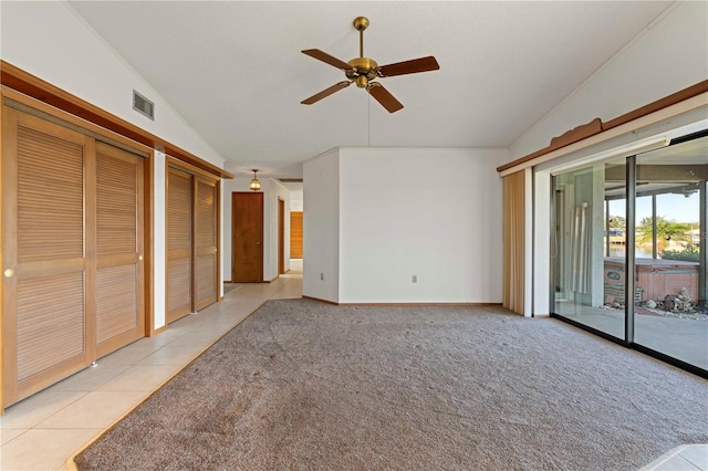 unfurnished living room with ceiling fan, lofted ceiling, and light tile patterned flooring