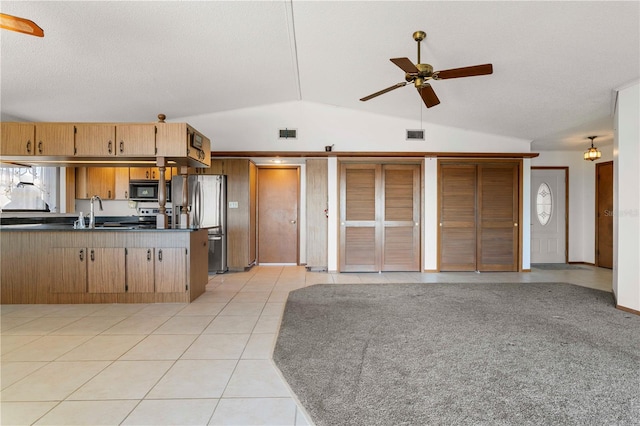 kitchen with ceiling fan, sink, stainless steel fridge with ice dispenser, lofted ceiling, and light tile patterned flooring