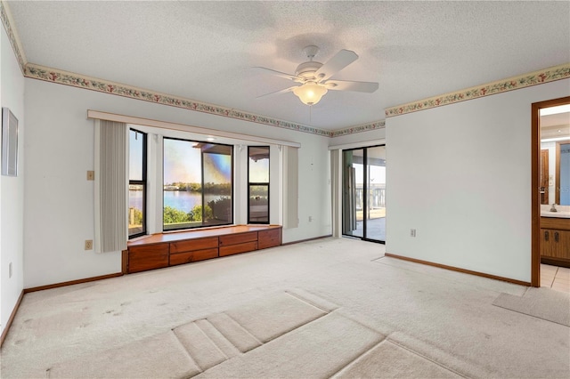 carpeted spare room with ceiling fan and a textured ceiling