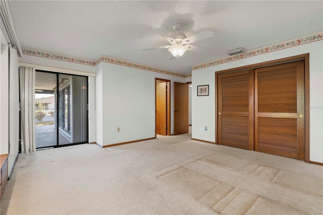 unfurnished bedroom with access to exterior, ceiling fan, light colored carpet, a textured ceiling, and a closet