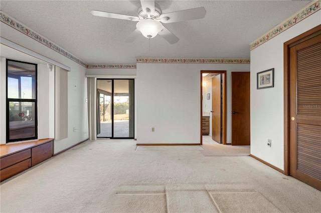 unfurnished bedroom featuring access to exterior, light carpet, ceiling fan, and multiple windows