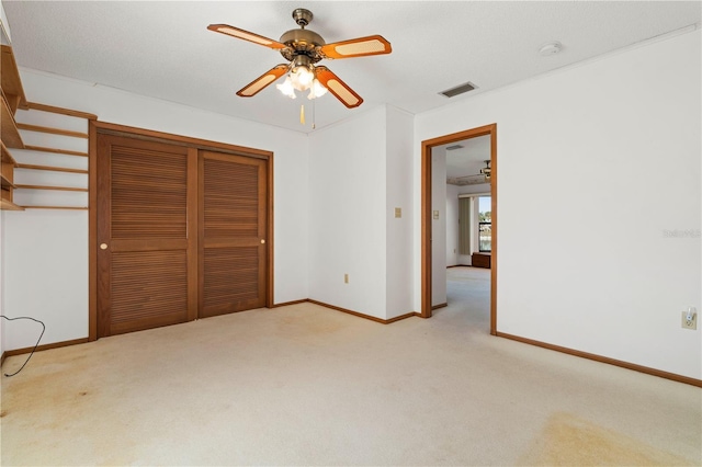 unfurnished bedroom with ceiling fan, a closet, and light colored carpet