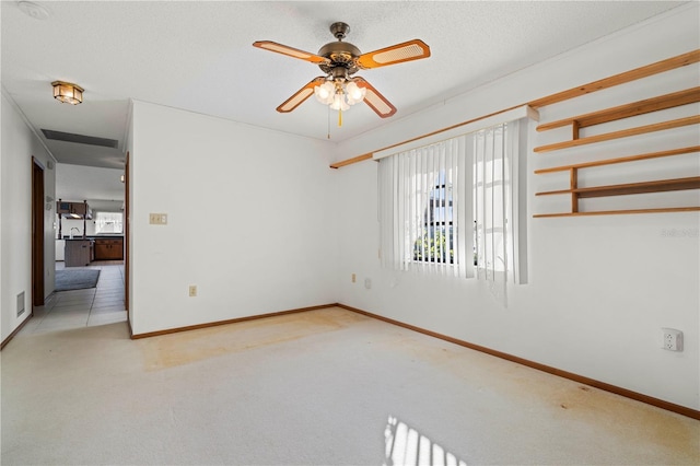 carpeted spare room featuring ceiling fan