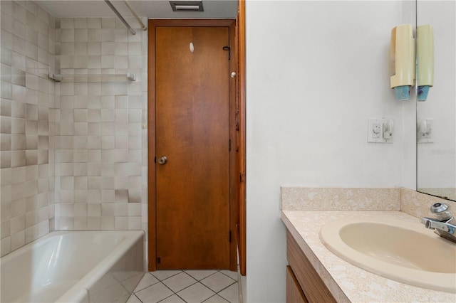 bathroom featuring tile patterned flooring, vanity, and tiled shower / bath