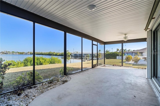 unfurnished sunroom featuring a water view, ceiling fan, and a healthy amount of sunlight