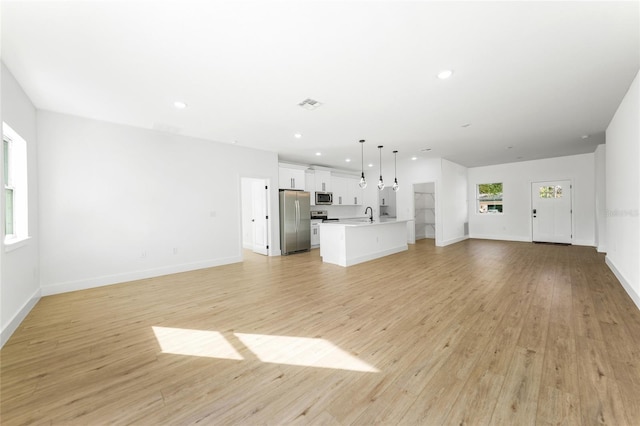 unfurnished living room featuring sink and light wood-type flooring