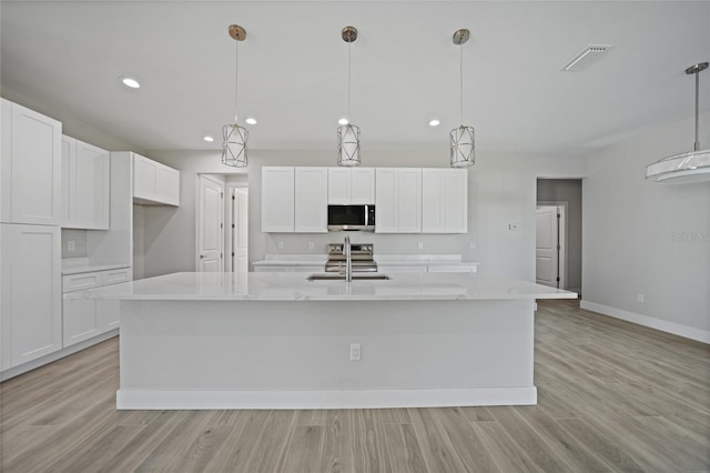 kitchen with white cabinetry, an island with sink, and stainless steel appliances