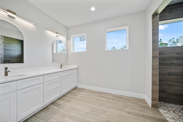 bathroom featuring wood-type flooring, vanity, a healthy amount of sunlight, and walk in shower