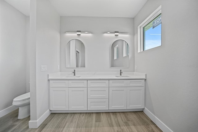 bathroom with vanity, toilet, and wood-type flooring