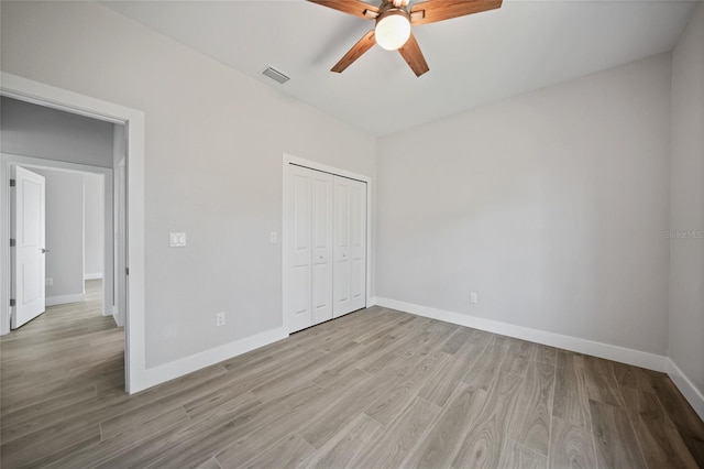 unfurnished bedroom with ceiling fan, a closet, and light hardwood / wood-style floors