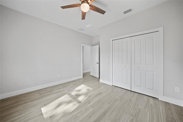 unfurnished bedroom featuring ceiling fan, light hardwood / wood-style flooring, and a closet