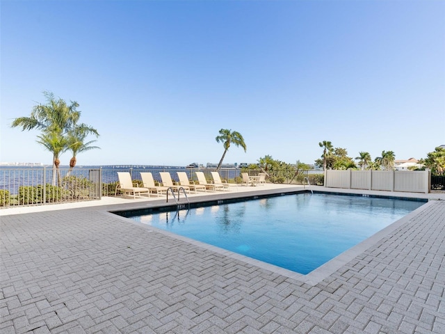 view of pool featuring a patio area and a water view