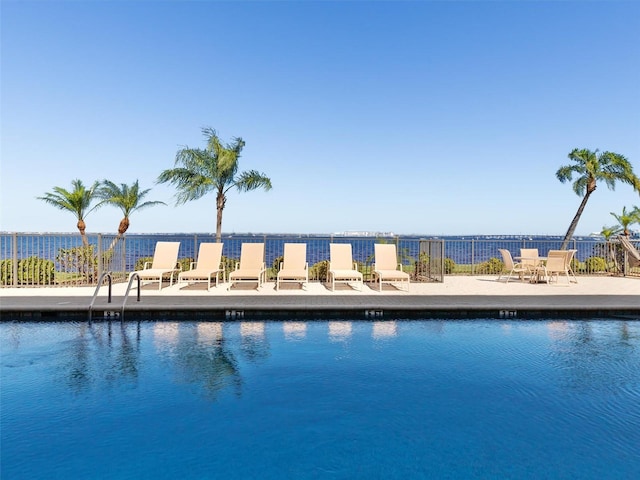 view of swimming pool featuring a patio area and a water view