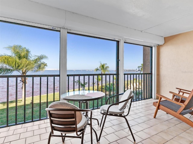 sunroom / solarium featuring a water view