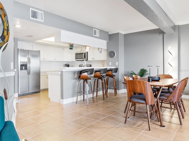 tiled dining room featuring crown molding