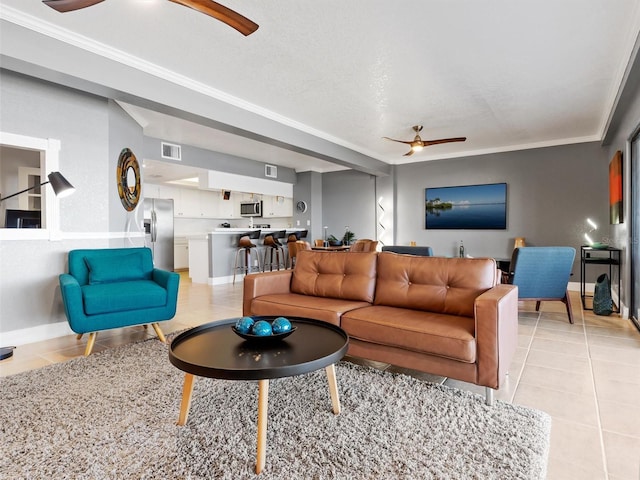 tiled living room featuring ceiling fan and ornamental molding