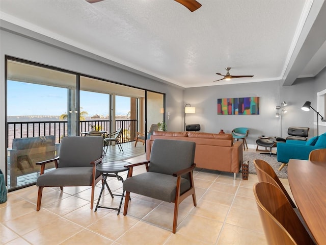 living room featuring ceiling fan, light tile patterned flooring, and a textured ceiling