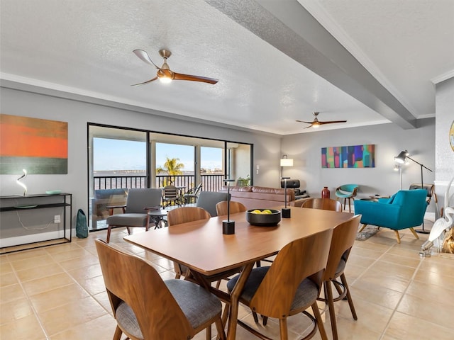 tiled dining space featuring ceiling fan and a textured ceiling