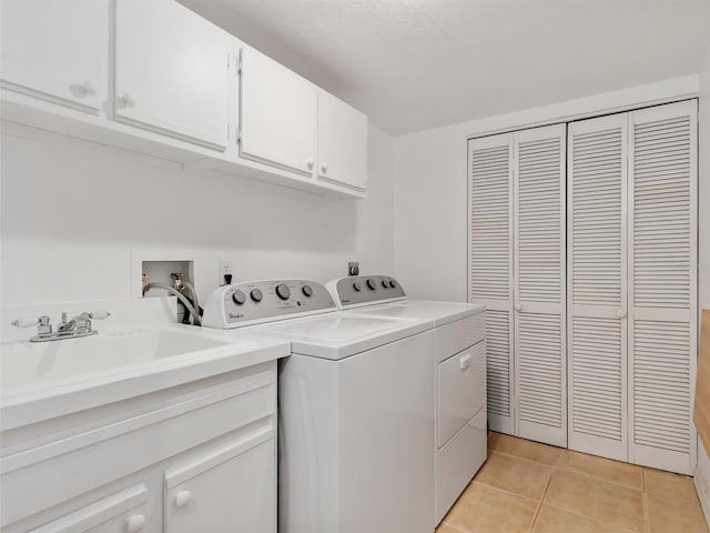 laundry area featuring cabinets, independent washer and dryer, sink, and light tile patterned floors