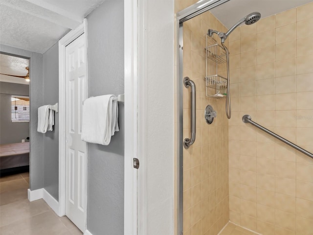 bathroom with a textured ceiling and tiled shower