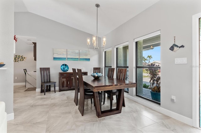 dining space with lofted ceiling and an inviting chandelier