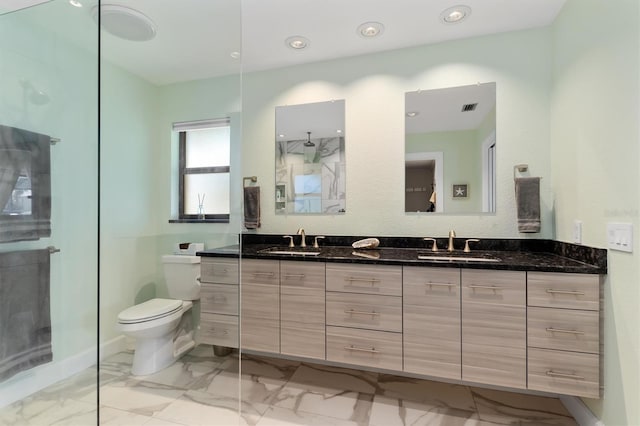 bathroom featuring vanity, toilet, and walk in shower