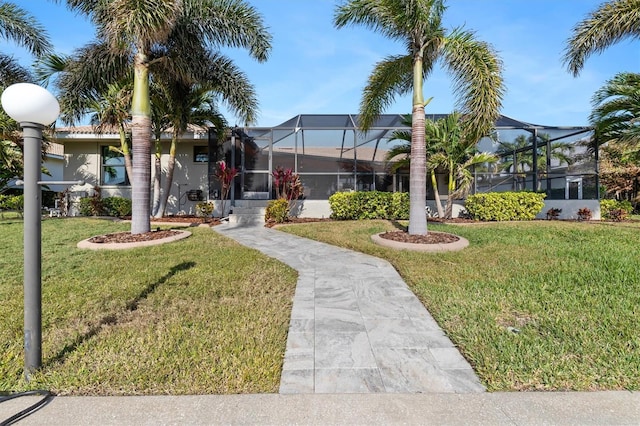 view of front of house with a lanai and a front lawn