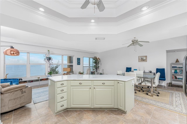 kitchen featuring a water view, a tray ceiling, ornamental molding, and a center island