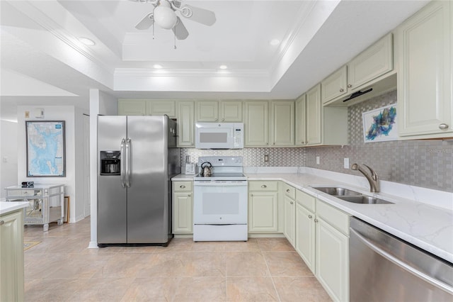 kitchen with ceiling fan, stainless steel appliances, a raised ceiling, light stone countertops, and sink