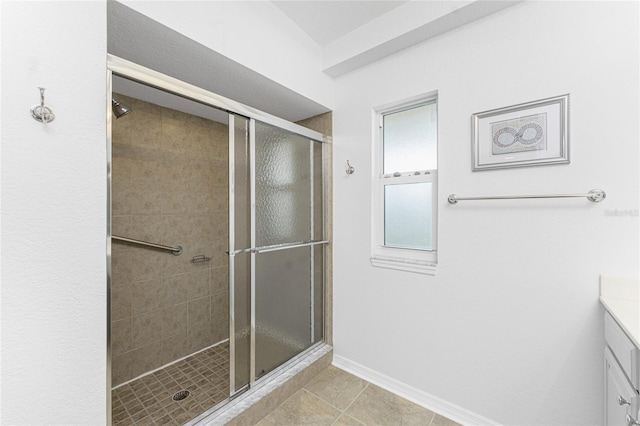 bathroom featuring tile patterned flooring, walk in shower, and vanity