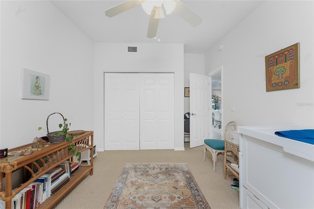 interior space with ceiling fan and light colored carpet