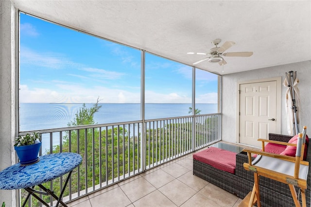 sunroom featuring a water view and ceiling fan