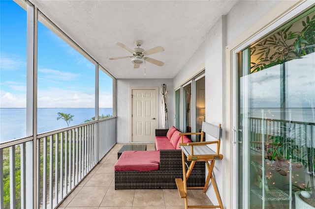 sunroom featuring a water view and ceiling fan