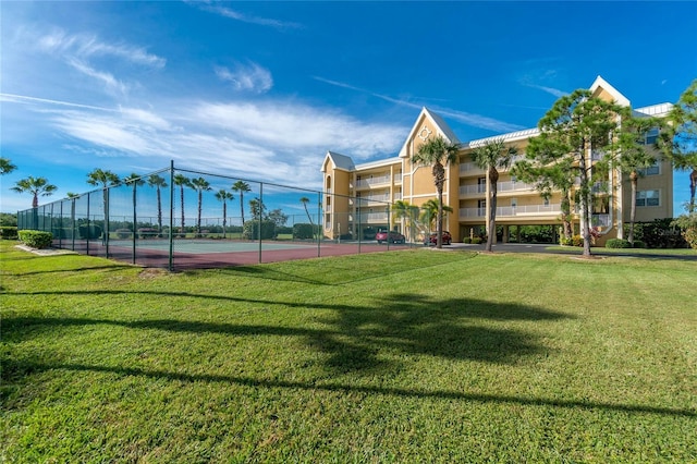 view of sport court featuring a lawn