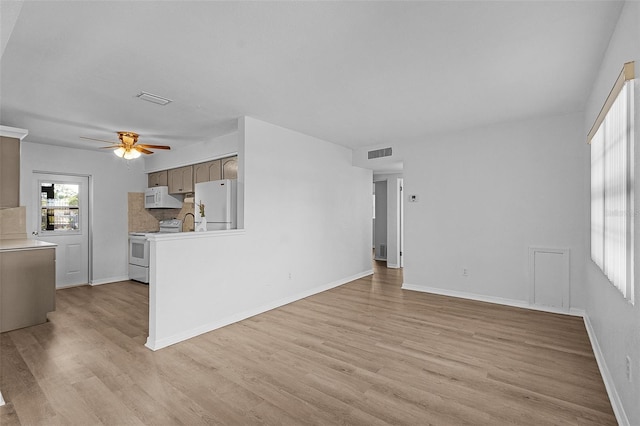 unfurnished living room with ceiling fan, light hardwood / wood-style flooring, and sink