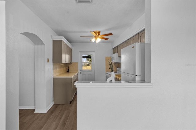 kitchen with white appliances, light hardwood / wood-style floors, ceiling fan, and backsplash